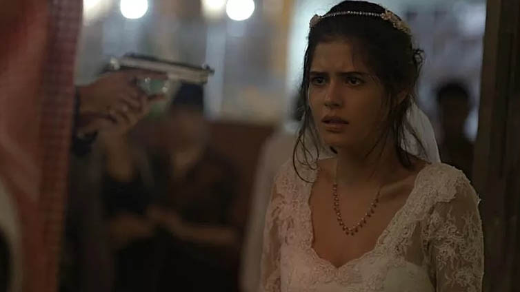 Laila (Julia Dalavia) na mira do revolver de Aziz em Orfãos da Terra