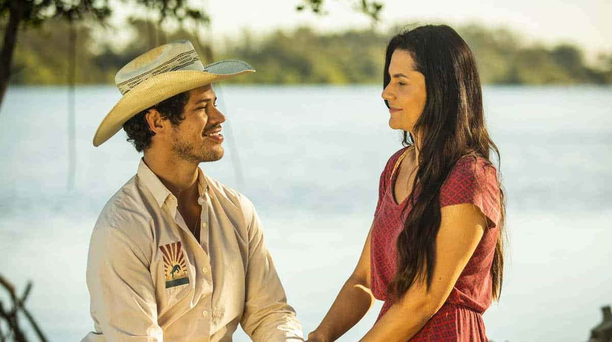 Tadeu e Zefa de mãos dadas com um rio ao fundo na novela Pantanal