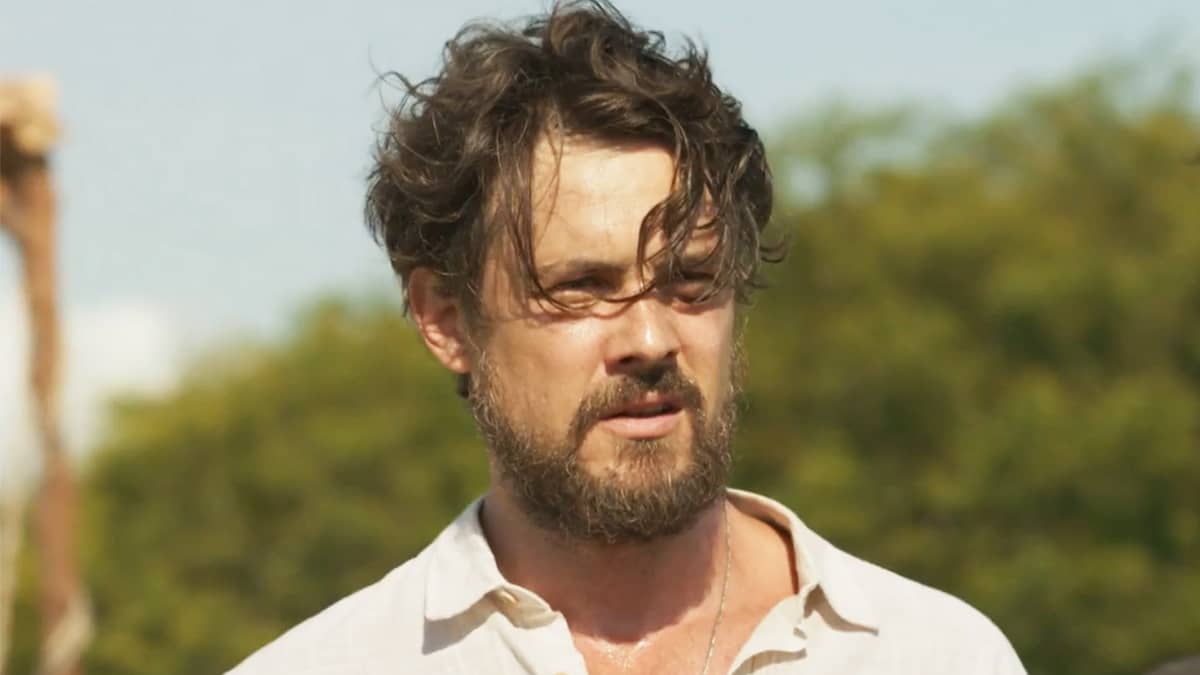 José, personagem de Sérgio Guizé. Na cena de Mar do Sertão, ele aparece sozinho, com um fundo de árvores verdes atrás.