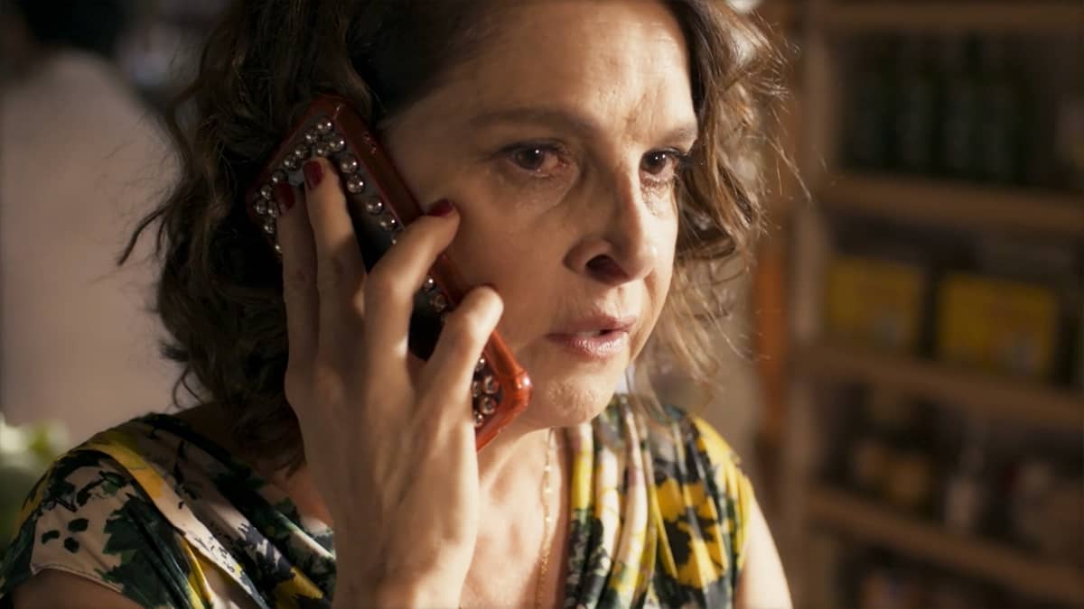 Núbia, personagem de Drica Moraes, falando ao celular na novela Travessia