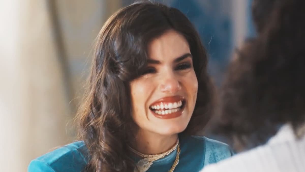 Marê, com uma roupa azul, sorrindo em cena da novela Amor Perfeito