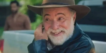 Antônio sorrindo e com a mão esquerda na barba em Terra e Paixão.