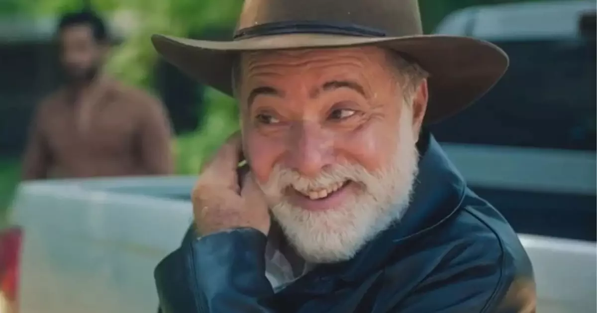 Antônio sorrindo e com a mão esquerda na barba em Terra e Paixão.