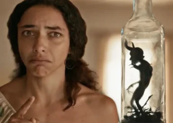 Joana, assustada, encarando o diabinho de Tião na garrafa em Renascer.