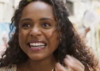 Beatriz, personagem de Duda Santos, sorrindo durante um bloco de rua em cena da novela Garota do Momento.