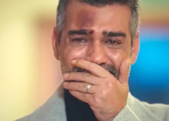 Sarp, com o rosto ferido, coloca a mão na boca, demonstrando emoção, em cena de Força de Mulher.