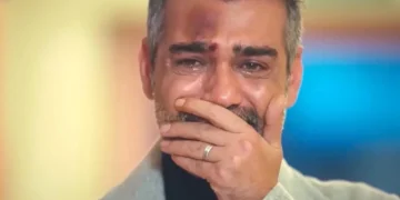 Sarp, com o rosto ferido, coloca a mão na boca, demonstrando emoção, em cena de Força de Mulher.