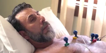 Hugo, deitado na cama durante exames, em cena de Mania de Você.