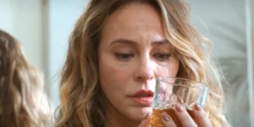 Heleninha olhando para uma taça de Whisky em cena de Vale Tudo.