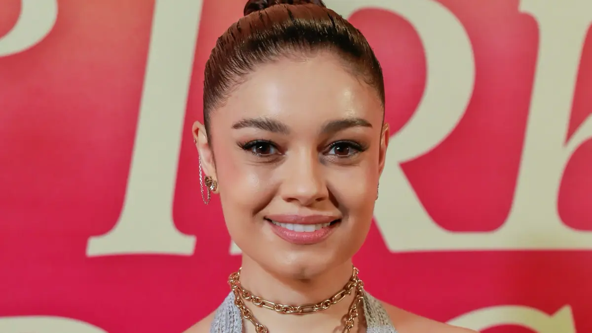 Sophie Charlotte sorrindo; atrás um fundo vermelho.