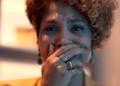 Lena com a mão na boca, emocionada, em cena da novela Três Graças.
