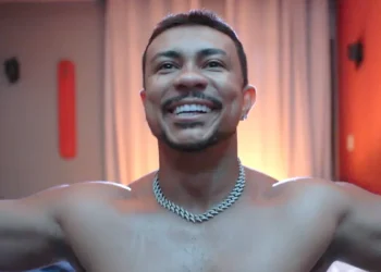 Bagdá sem camisa, de braços abertos e sorrindo em cena da novela Três Graças.