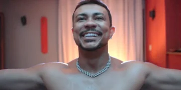 Bagdá sem camisa, de braços abertos e sorrindo em cena da novela Três Graças.