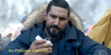 Heitor em um local frio, segurando uma foto de Arthur Brandão em Quem Ama Cuida.