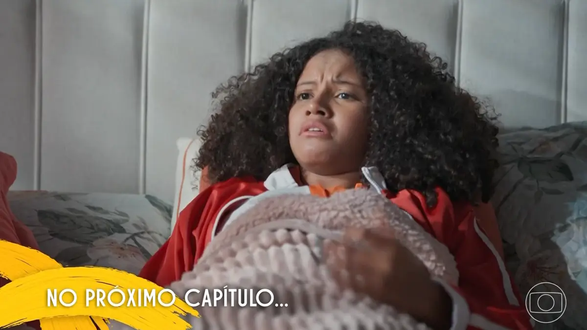 Glorinha deitada na cama em cena da novela Por Você.